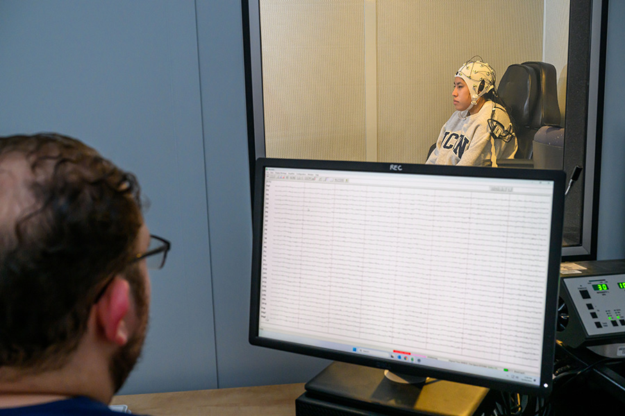 A researcher monitors the sound booth facility in the Electrophysiology Resource Laboratory.